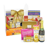 Gift hamper with snacks, chocolates, grape juice and gold ribbon for flower delivery