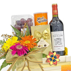 Flower delivery gift set with colorful gerbera bouquet, wine, chocolates, and fruit