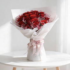 Fresh red rose bouquet with pink filler flowers, wrapped for flower delivery