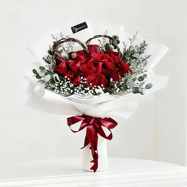 Red rose bouquet with white baby's breath, greenery, and heart-shaped twigs for flower delivery