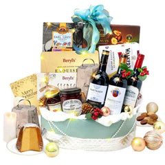 Festive flower delivery gift basket with red wine, chocolates, snacks, and ornaments