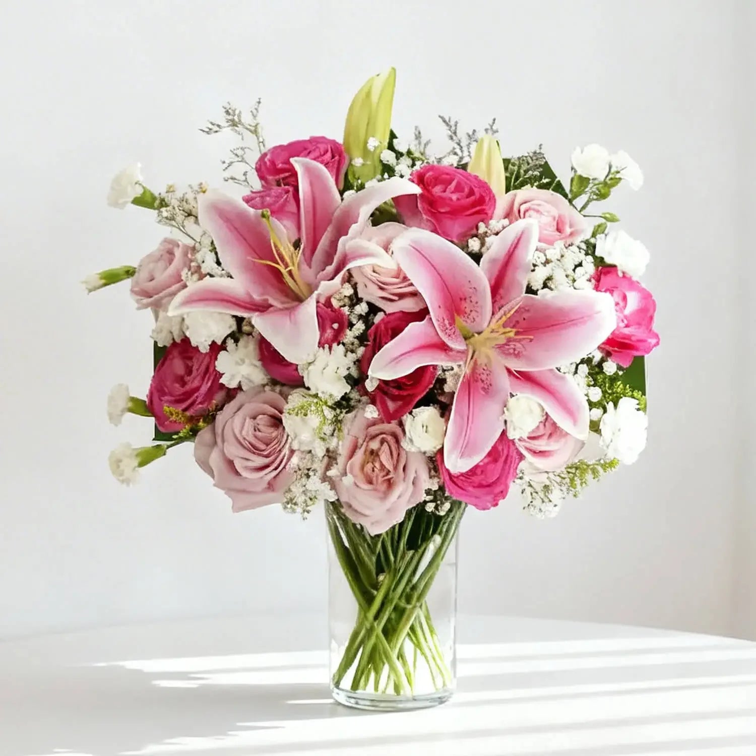 Elegant pink lily and rose bouquet in glass vase for flower delivery