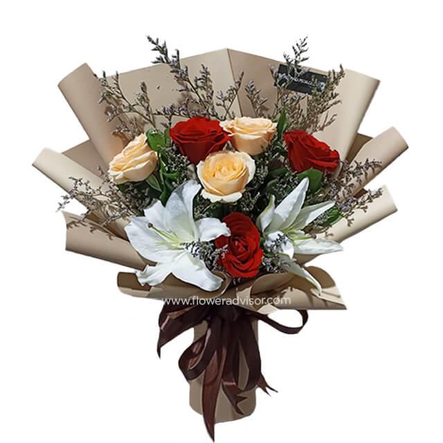 Hand bouquet with peach and red roses, white lilies, perfect for flower delivery in Singapore