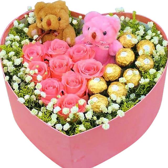 Heart-shaped gift box with pink roses, chocolates, teddy bears, for flower delivery