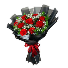 Red rose flower bouquet for delivery, wrapped in black paper with baby's breath and greenery