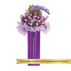 Purple flower stand with pink roses and congratulatory sign for flower delivery