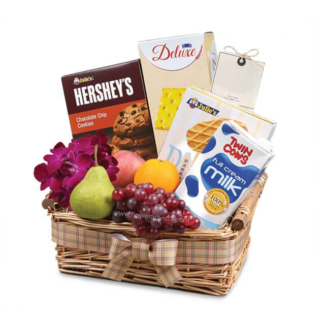 Fruit and flower hamper with fresh grapes, pear, cookies, milk, and orchids for flower delivery