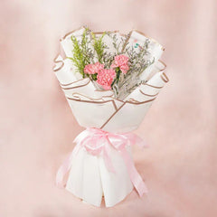 Pink carnation bouquet wrapped in white paper with pink ribbon, perfect for flower delivery