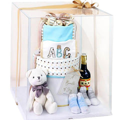 Baby gift hamper with plush bear, baby clothes, socks, and bottle, ideal for flower delivery