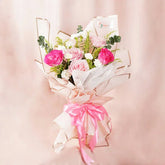 Soft pastel pink flower bouquet with roses for flower delivery, wrapped with pink ribbon.