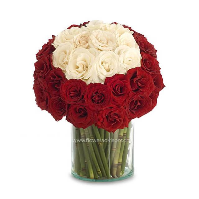 Elegant bouquet of fresh red and white roses in a glass vase for flower delivery