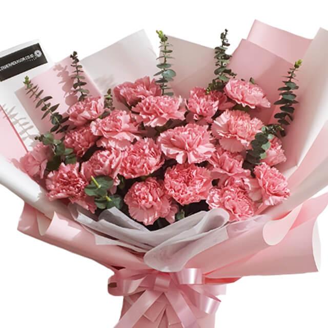 Pink carnation bouquet with eucalyptus, wrapped in pastel paper for flower delivery