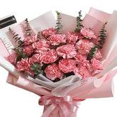 Pink carnation bouquet with eucalyptus, wrapped in pastel paper for flower delivery
