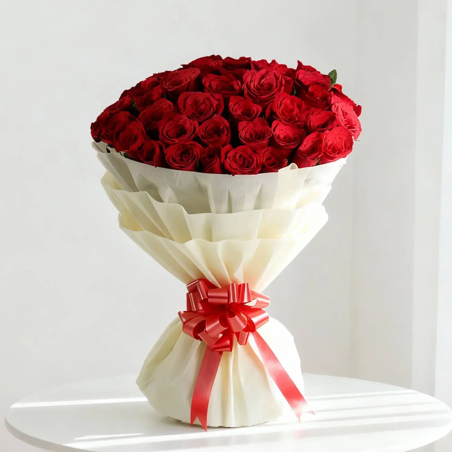 Elegant bouquet of red roses with cream wrapping and red ribbon for flower delivery