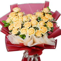 Elegant yellow rose bouquet with baby's breath for flower delivery, wrapped in red paper.