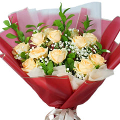 Elegant bouquet of pale yellow roses with baby's breath for flower delivery, wrapped in red paper.