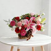Fresh flower delivery basket with pink lilies, red roses, carnations and greenery arrangement
