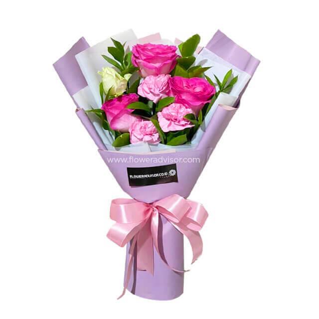 Pink and white flower bouquet with greenery, wrapped in pastel paper, for flower delivery
