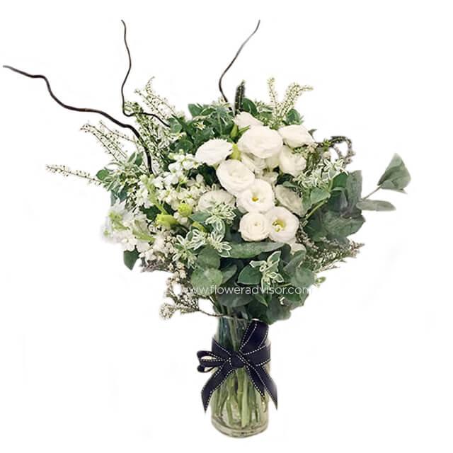 Elegant white flower bouquet in glass vase for flower delivery