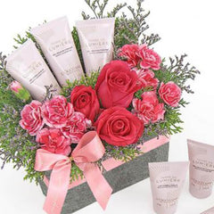 Pink roses and carnations arrangement with gift creams in a box for flower delivery