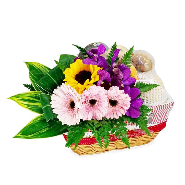 Fresh flower and fruit basket with sunflowers, orchids, and seasonal fruit for flower delivery