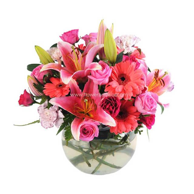 Pink lilies, gerberas, and roses in a glass vase for fresh flower delivery