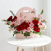 Hand-carry floral arrangement with red and pink flowers for flower delivery in Singapore