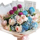 Charming pastel bouquet with pink roses, blue chrysanthemums, and purple pompom flowers for flower delivery.