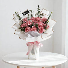 Pink carnation bouquet with eucalyptus in white wrap, flower delivery arrangement