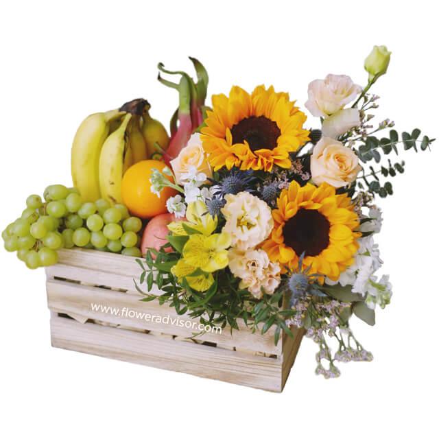 Flower delivery crate with sunflowers, mixed blooms, and assorted fresh fruits
