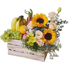 Flower delivery crate with sunflowers, mixed blooms, and assorted fresh fruits