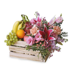 Fresh flower and fruit delivery crate with pink lilies, roses, bananas, grapes, and orange