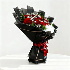 Elegant bouquet of red roses with baby's breath in black wrapping, ideal for flower delivery.