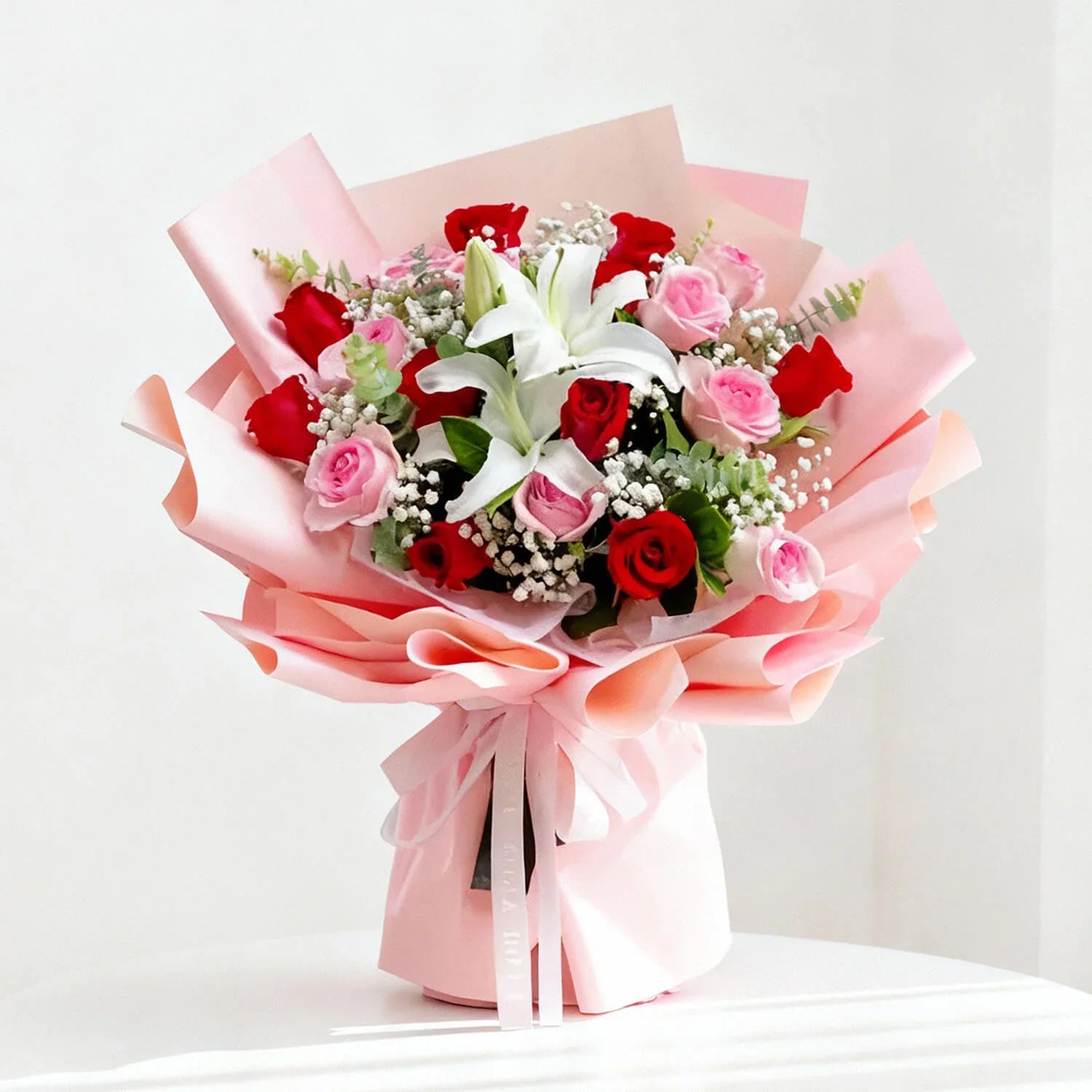 Beautiful flower delivery bouquet with red roses, pink roses, lilies, and baby's breath