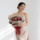 Woman holding a bouquet of red roses and baby's breath, perfect for flower delivery.