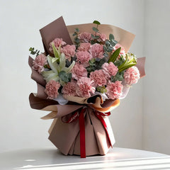 Elegant flower bouquet with pink carnations and white lilies, ready for flower delivery.