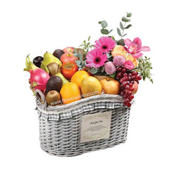 Flower and fruit basket for delivery with pink gerberas, roses, and assorted fresh fruits
