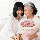 Smiling women sharing a pink flower bouquet, symbolizing flower delivery celebration