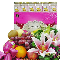 Flower delivery basket with fresh lilies, assorted fruits, and six bottles of Bird's Nest.