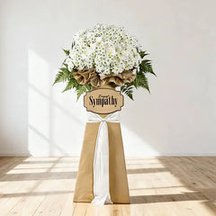 Large white sympathy flower stand with fresh blooms and greenery for condolence flower delivery