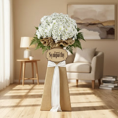 Sympathy flower arrangement with white blooms and greenery, ideal for delivery