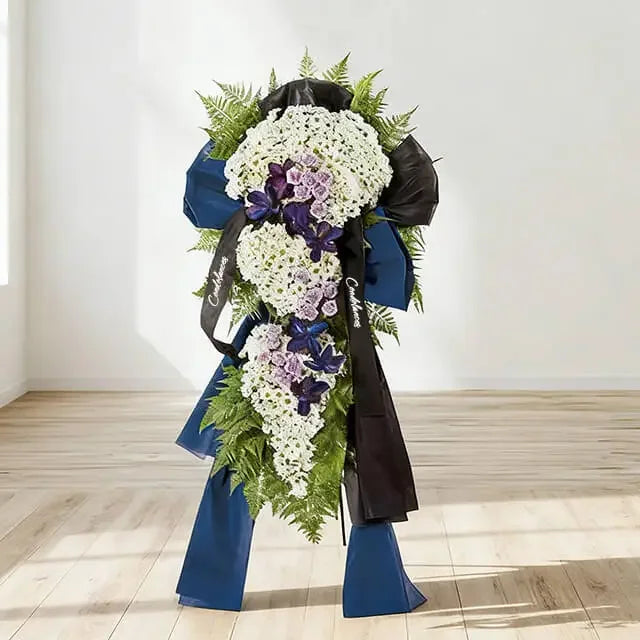 Elegant standing flower arrangement with white, purple blooms and green leaves for delivery