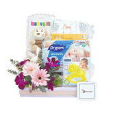 Newborn baby hamper with pink flowers, plush toy, diapers, and baby care items for delivery