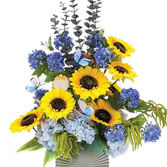 Artificial flower delivery arrangement with sunflowers, blue hydrangeas, and butterflies