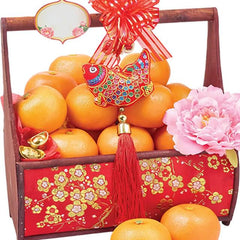 Festive hamper with fresh oranges, pink flower, and fish decoration for flower delivery