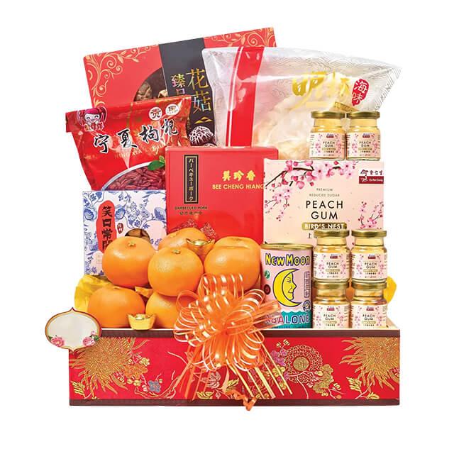Chinese New Year gift hamper with fresh oranges, festive snacks, and flower-themed ribbon, ideal for flower and hamper delivery.