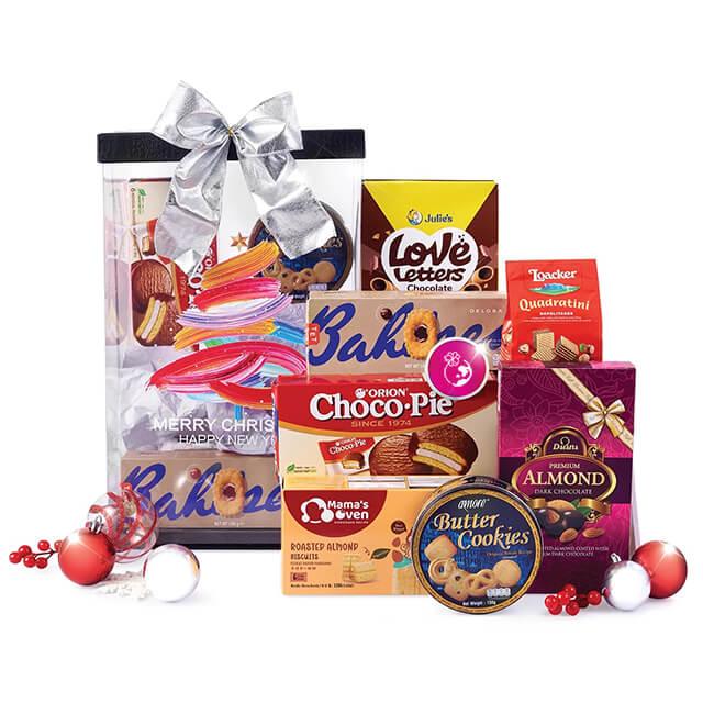 Christmas gift hamper with cookies, snacks, and festive decorations for flower delivery