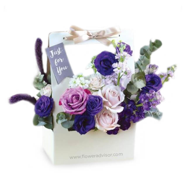 Purple and pink rose bouquet in a gift bag for flower delivery in Singapore