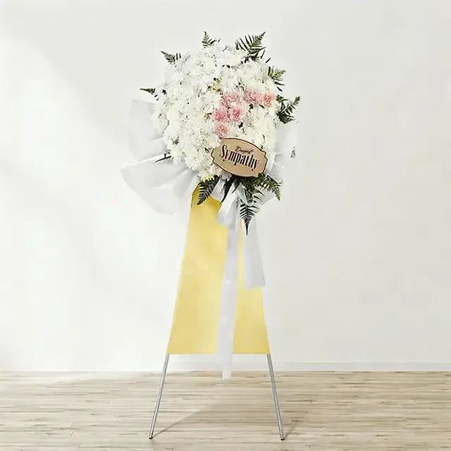 Elegant floral condolence wreath with white and pink flowers for flower delivery
