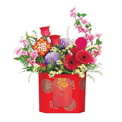 Festive flower arrangement with roses, gerberas, and mixed blooms in a red box for delivery
